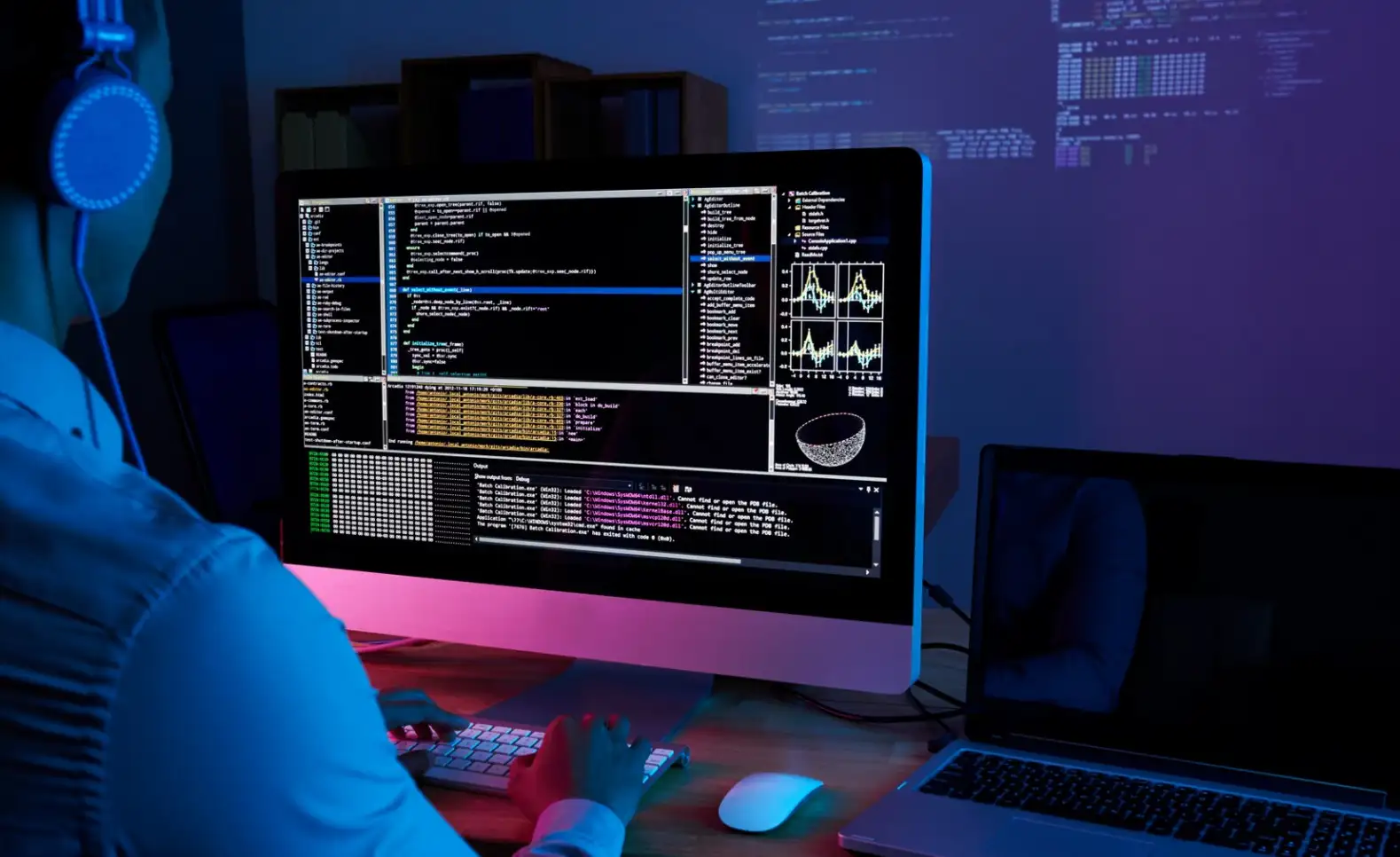 IT specialist checking code at his computer in the dark office