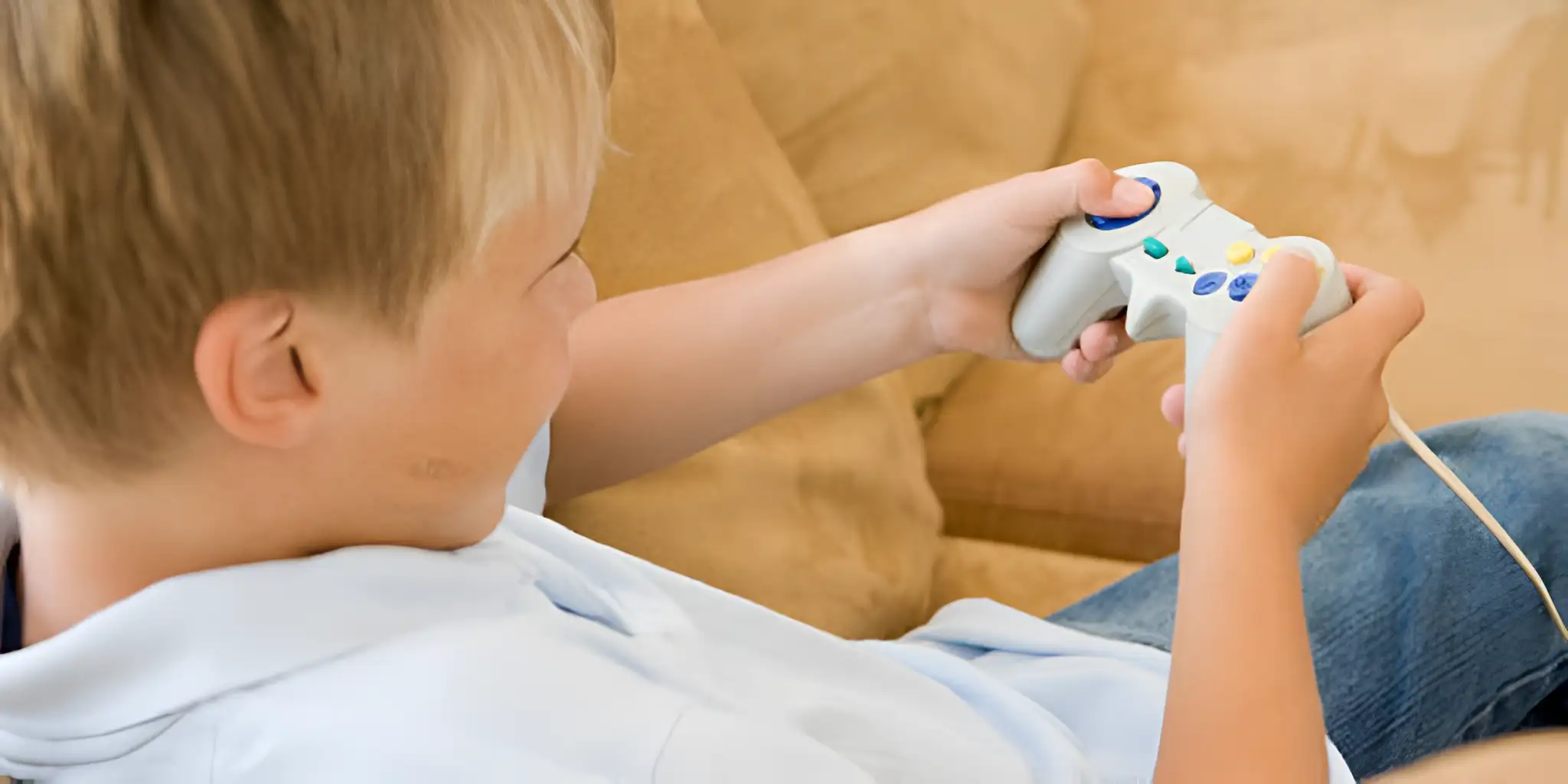 a boy is happily playing gamecube