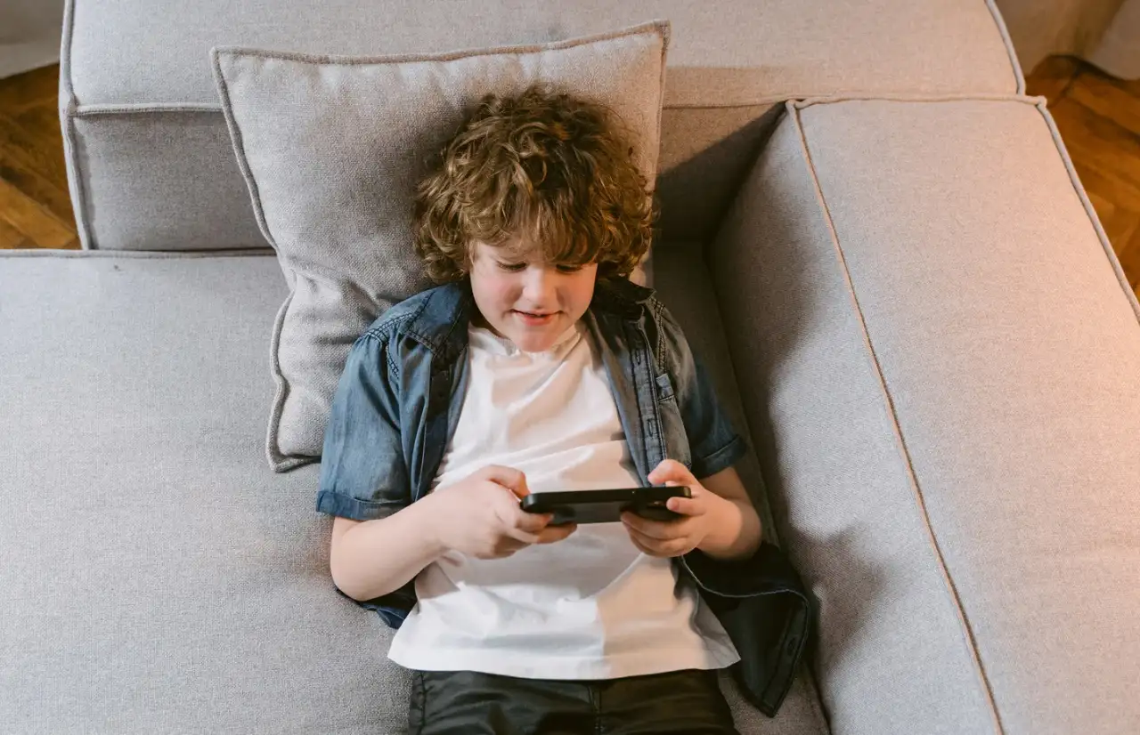 a boy playing games on the sofa