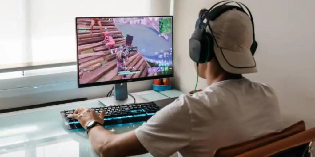 man with headphones playing a game on a computer