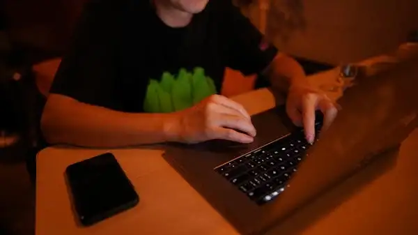 a person typing on a laptop on a desk