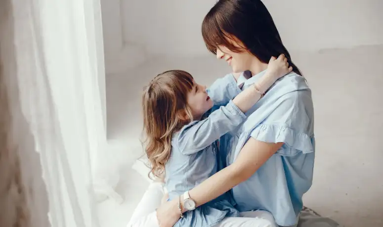 a mother holding her little daughter iher n arms