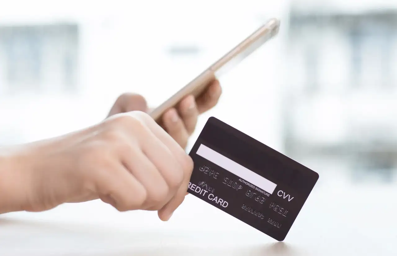 people holding a phone and a credit card