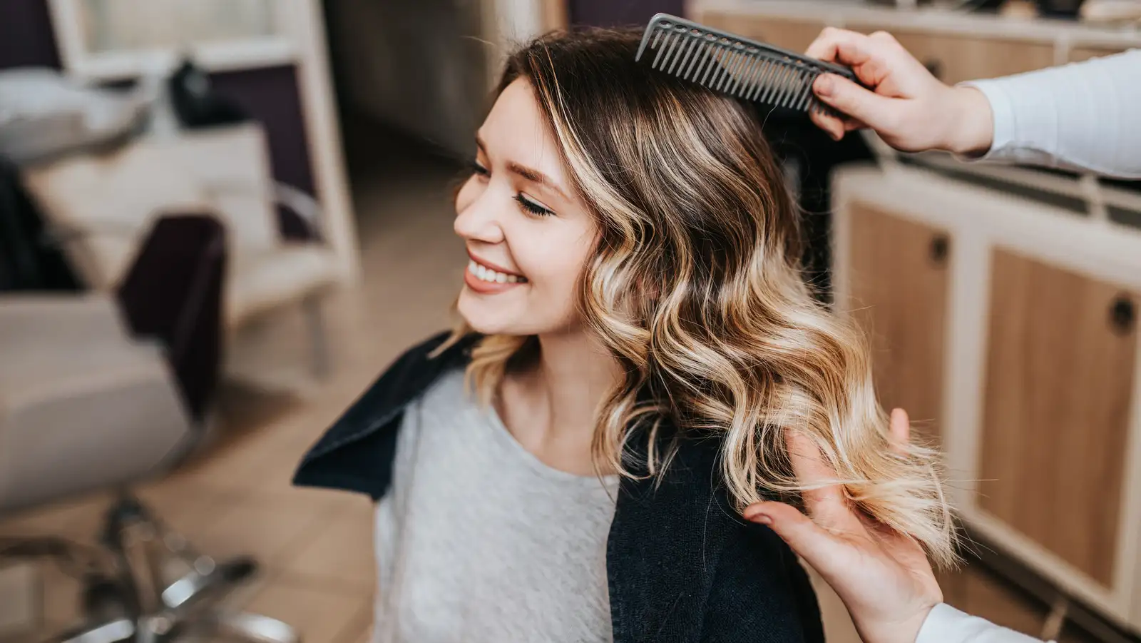 A professional hair stylist helping with a client, looking at hair color. A professional hair stylist helping with a client, looking at hair color.
