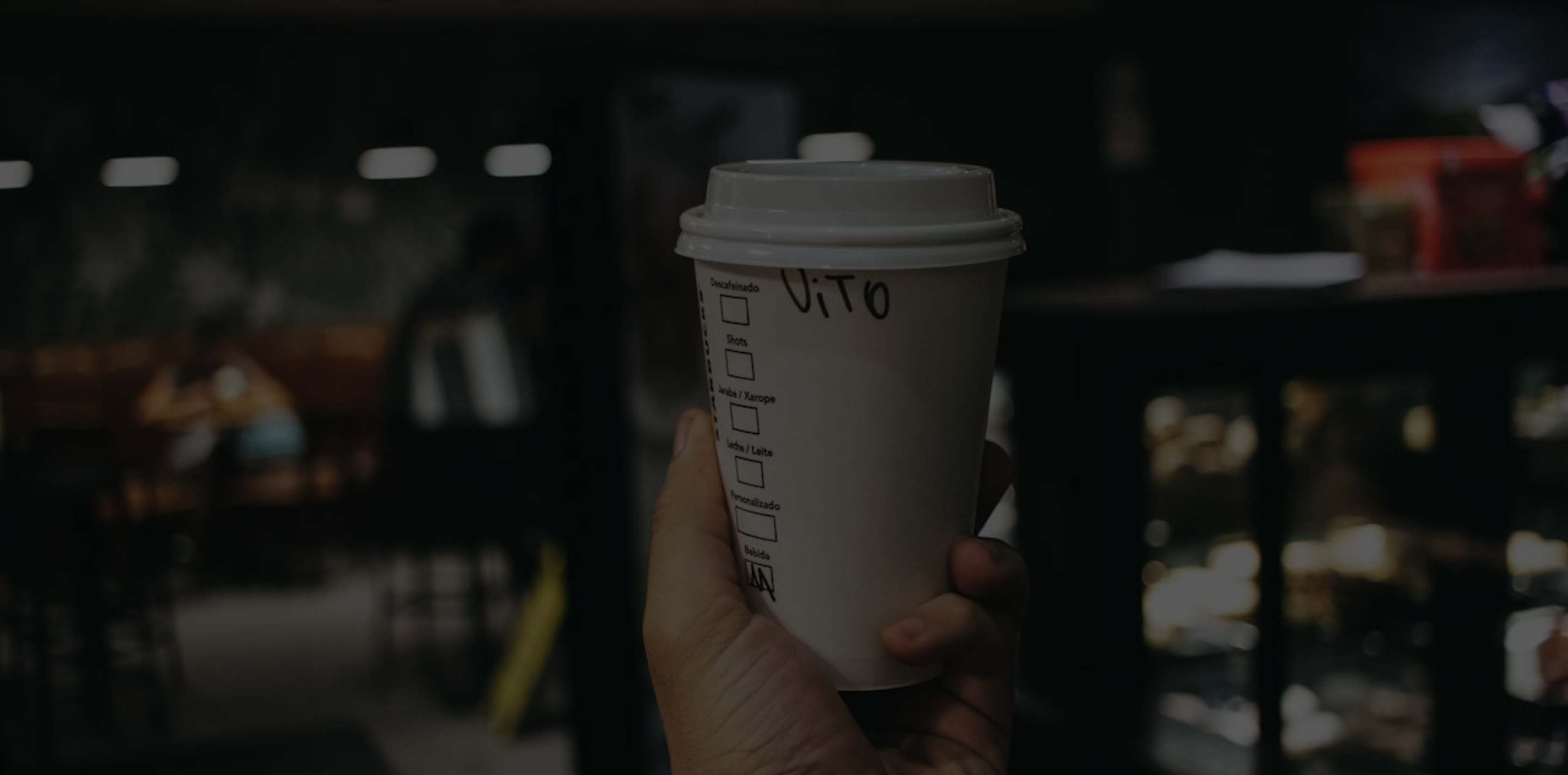 holding a cup of coffee with office background